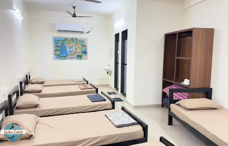 Six Bed Room, single beds and the wall map of Konkan